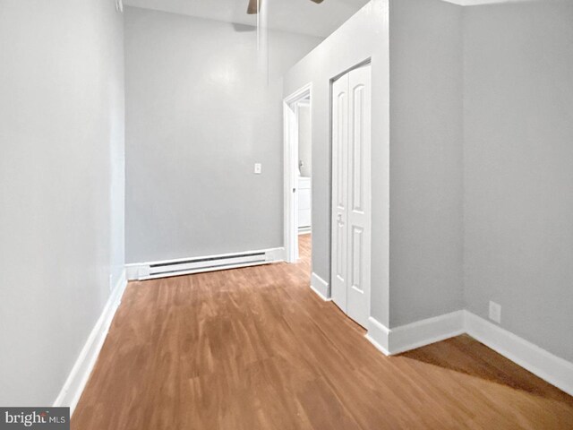 1812 Mcculloh St, Baltimore, MD 21217 - hallway featuring a baseboard heating unit, wood finished floors, and baseboards