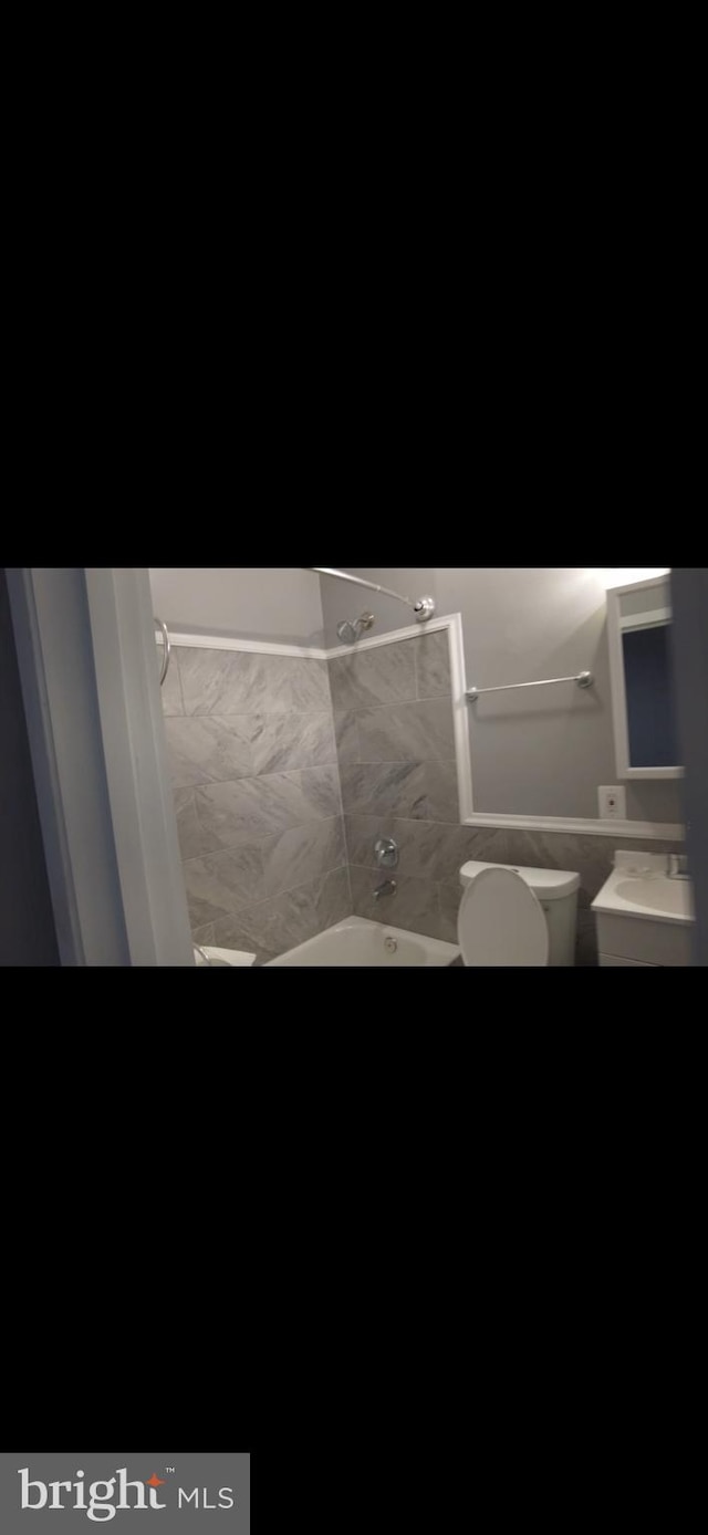 bathroom with bathtub / shower combination and toilet