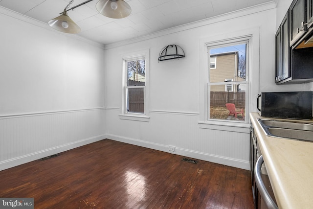 dining room featuring sink, crown molding, and dark wood-type flooring