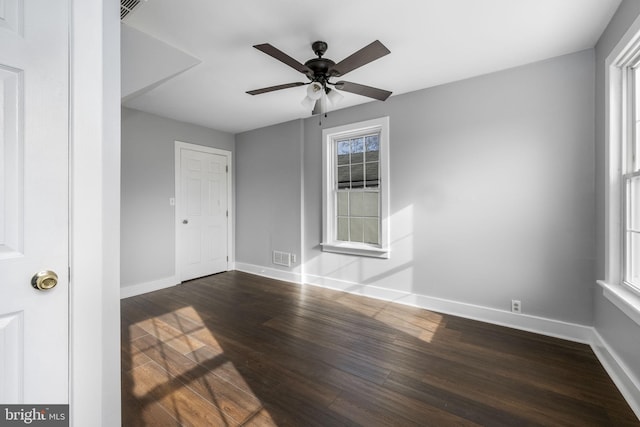 spare room featuring dark wood-type flooring and ceiling fan