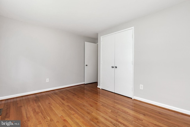 11501 Piney Lodge Rd, North Potomac, MD 20878 - unfurnished bedroom with light wood finished floors, baseboards, and a closet