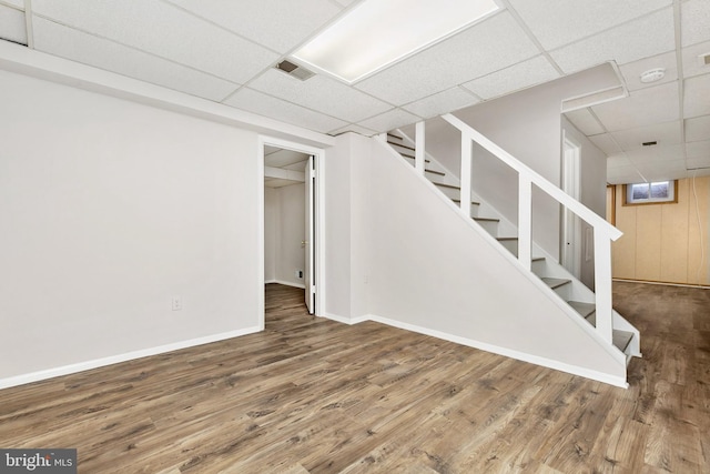 11501 Piney Lodge Rd, North Potomac, MD 20878 - finished basement featuring a paneled ceiling, stairs, wood finished floors, and baseboards