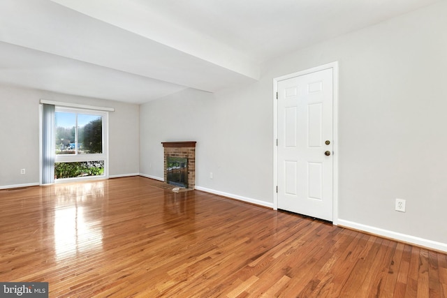 11501 Piney Lodge Rd, North Potomac, MD 20878 - unfurnished living room with wood finished floors, baseboards, and a brick fireplace