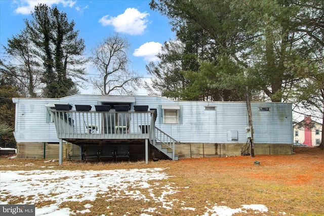 snow covered house with a wooden deck