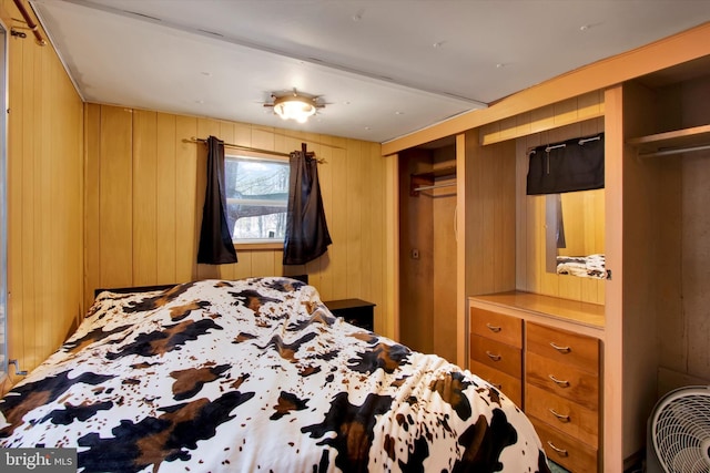 bedroom featuring wood walls