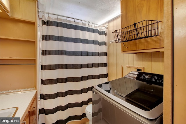 kitchen with washer / clothes dryer and wooden walls