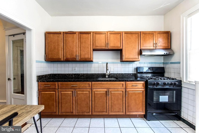 kitchen featuring a healthy amount of sunlight, sink, dark stone counters, and black range with gas cooktop