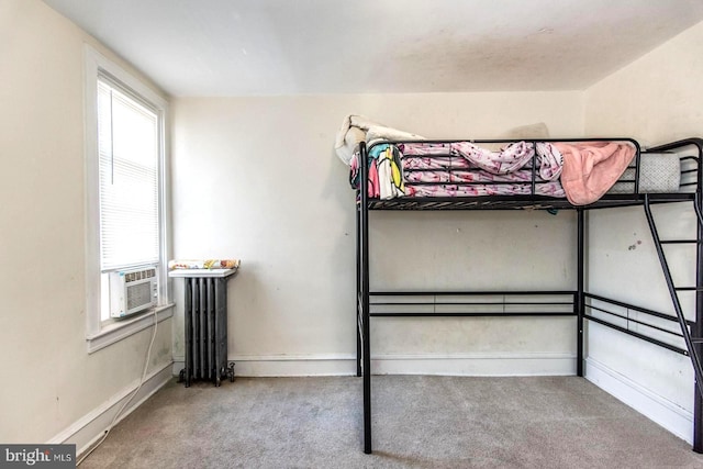 bedroom featuring cooling unit, radiator, and carpet