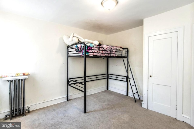 unfurnished bedroom featuring radiator heating unit and carpet floors