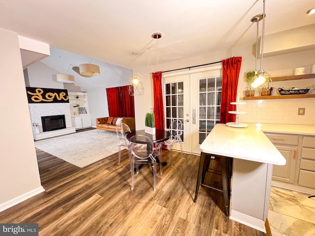 interior space with wood-type flooring, lofted ceiling, and french doors