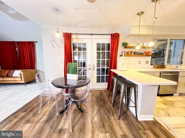 dining area featuring hardwood / wood-style floors, sink, and french doors