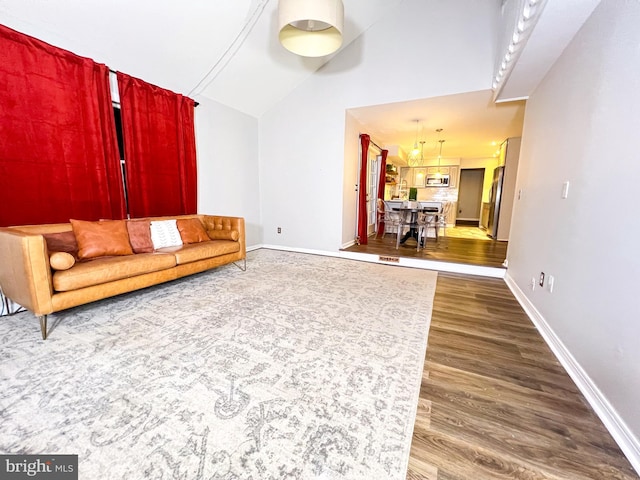 living room with high vaulted ceiling and hardwood / wood-style floors