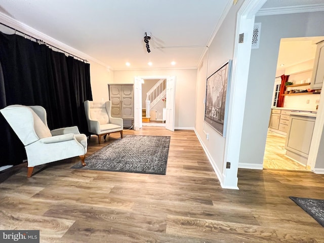 sitting room featuring ornamental molding and light hardwood / wood-style floors