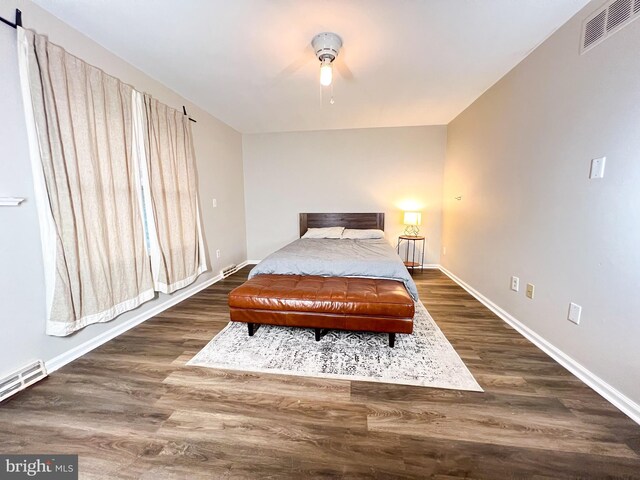 bedroom with a baseboard radiator and dark hardwood / wood-style flooring