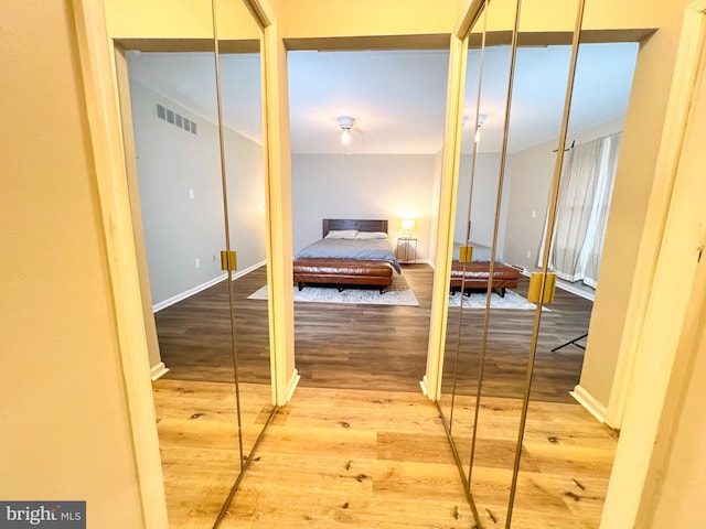 bedroom featuring wood-type flooring and multiple closets