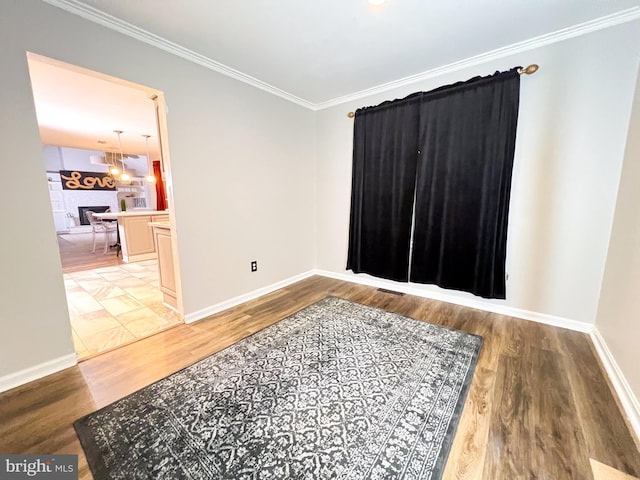 spare room featuring crown molding and hardwood / wood-style floors