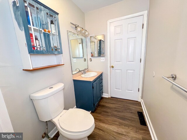 bathroom with vanity, hardwood / wood-style flooring, and toilet