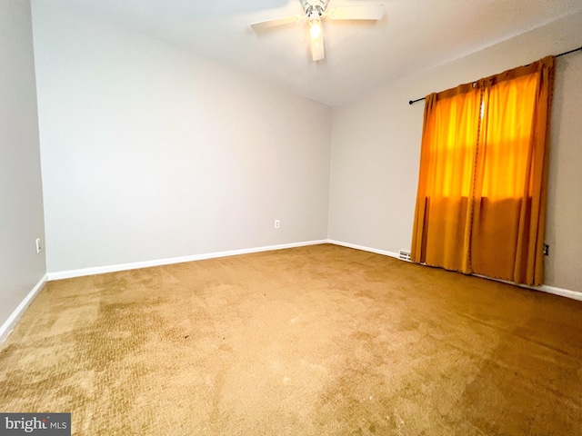 carpeted spare room with ceiling fan