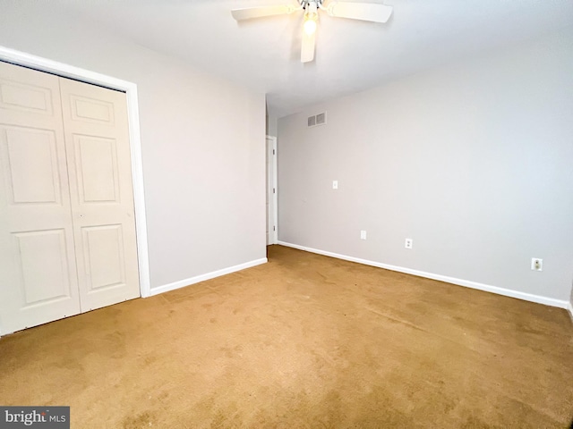 unfurnished bedroom with ceiling fan, carpet floors, and a closet