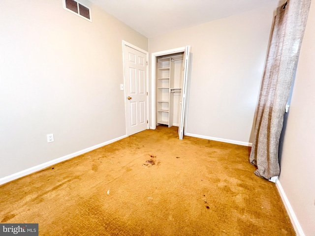 unfurnished bedroom with carpet flooring and a closet