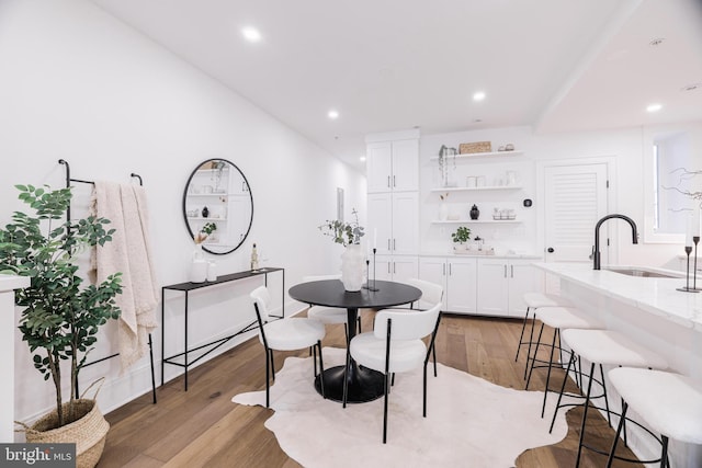 dining space with sink and light hardwood / wood-style floors