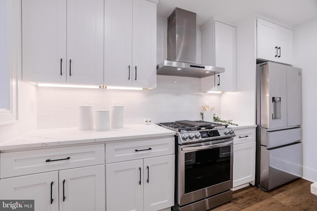 kitchen featuring stainless steel appliances, white cabinetry, backsplash, and wall chimney exhaust hood