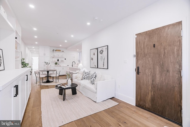 living room with sink and light hardwood / wood-style flooring