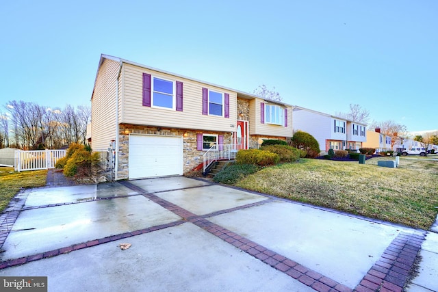 bi-level home with a garage and a front lawn