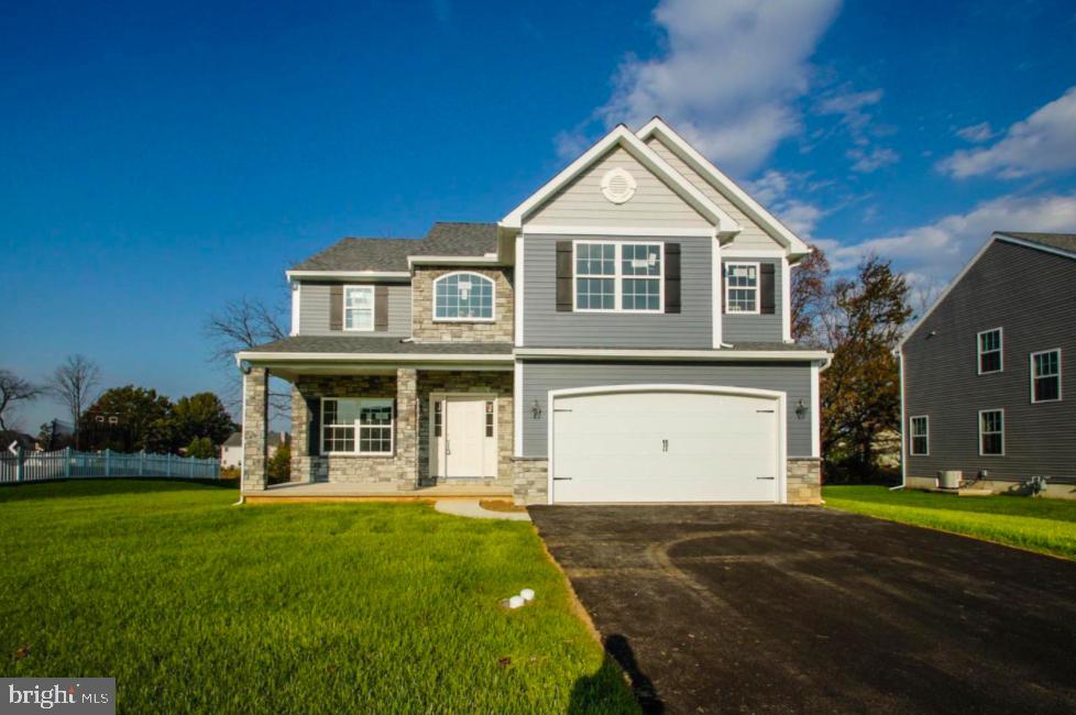 view of front of property with a garage, a porch, central air condition unit, and a front lawn