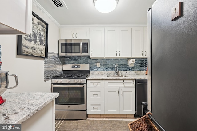 kitchen featuring stainless steel appliances, white cabinetry, sink, and light stone counters