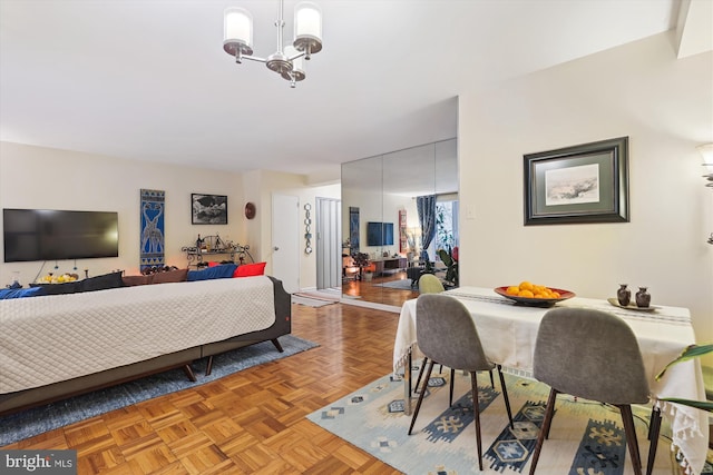 bedroom featuring light parquet flooring, a chandelier, and a closet