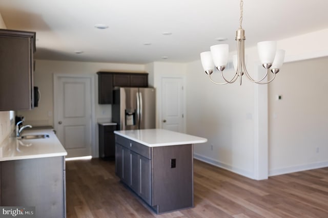 kitchen with dark brown cabinetry, sink, a center island, and stainless steel refrigerator with ice dispenser