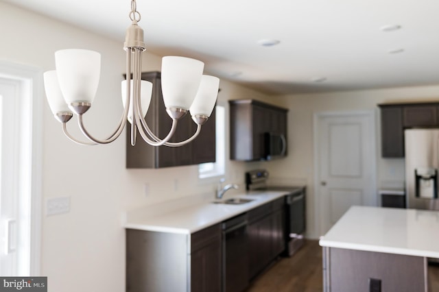 kitchen featuring electric stove, sink, dishwasher, dark brown cabinets, and a center island