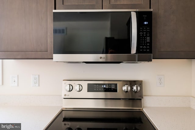 kitchen with dark brown cabinets, stainless steel range with electric cooktop, and mail boxes