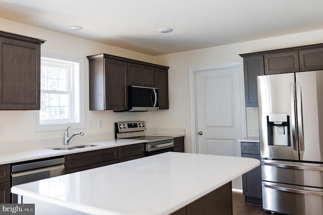 kitchen featuring dark brown cabinetry, appliances with stainless steel finishes, sink, and a kitchen island