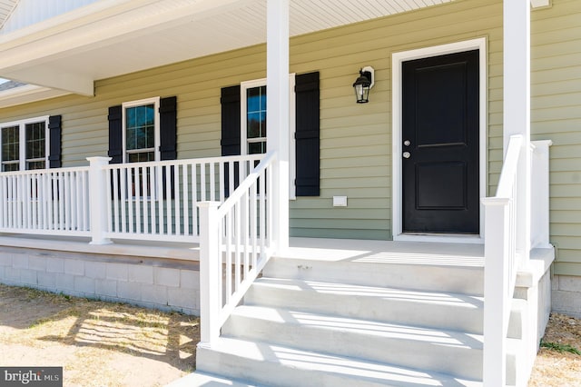 view of exterior entry with a porch