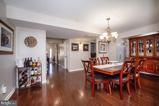 dining room with a notable chandelier and dark wood-type flooring