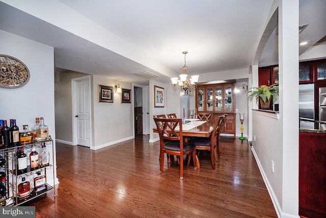 dining area with an inviting chandelier and dark hardwood / wood-style flooring