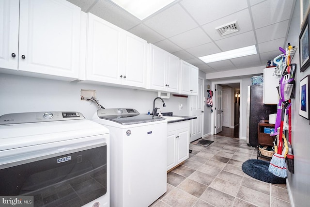 washroom featuring cabinets, separate washer and dryer, and sink