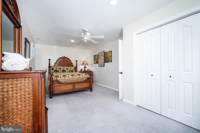 bedroom featuring ceiling fan, light colored carpet, and a closet