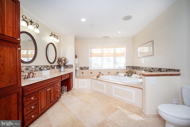 bathroom with a tub to relax in, toilet, and vanity