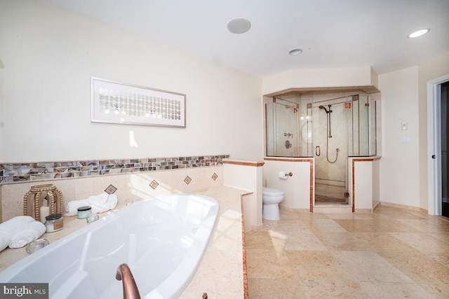 bathroom featuring shower with separate bathtub and toilet