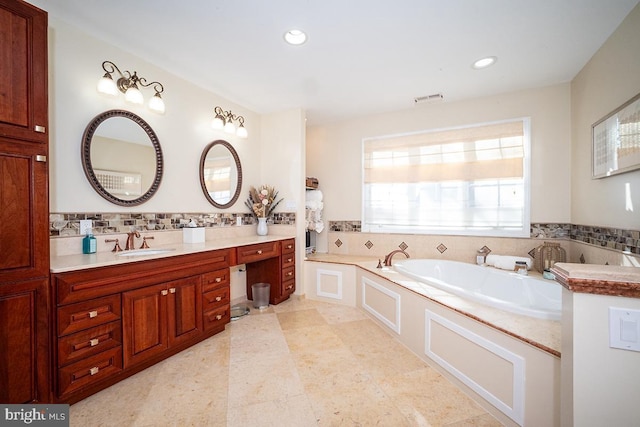 bathroom with vanity, a bath, and tile walls