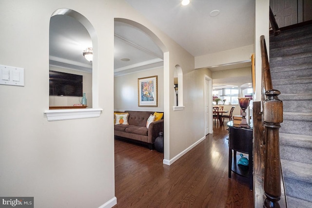 hallway with dark wood-type flooring and ornamental molding