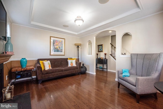 living room featuring crown molding, dark hardwood / wood-style floors, and a raised ceiling