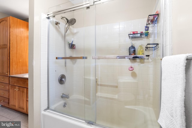 bathroom featuring tile patterned flooring and bath / shower combo with glass door