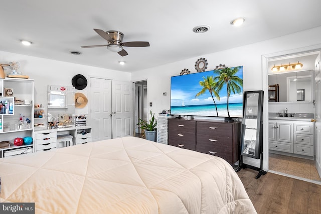 bedroom with ceiling fan, sink, connected bathroom, and hardwood / wood-style floors