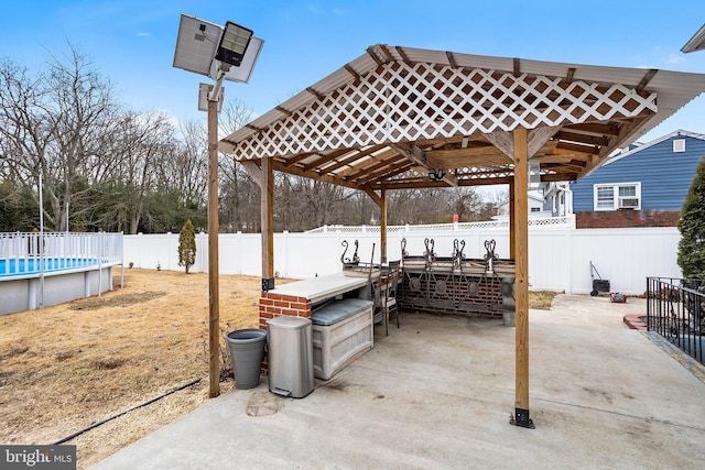 view of patio / terrace featuring a fenced in pool and exterior bar