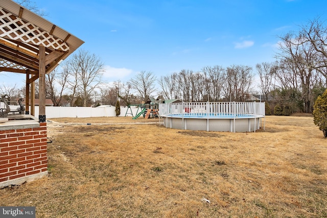 view of yard featuring a fenced in pool and a playground