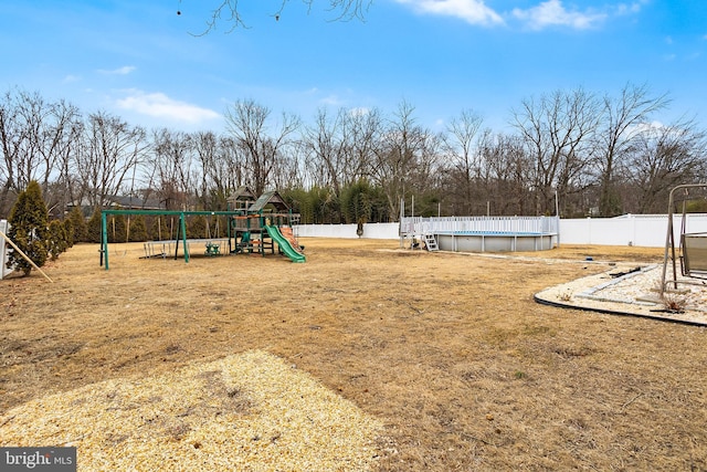 view of yard featuring a fenced in pool and a playground